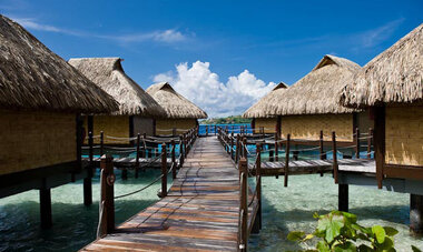 The bungalow-lined pontoon of the Maitai Polynesia Bora Bora resort stretch into the clear waters of the Bora Bora lagoon.